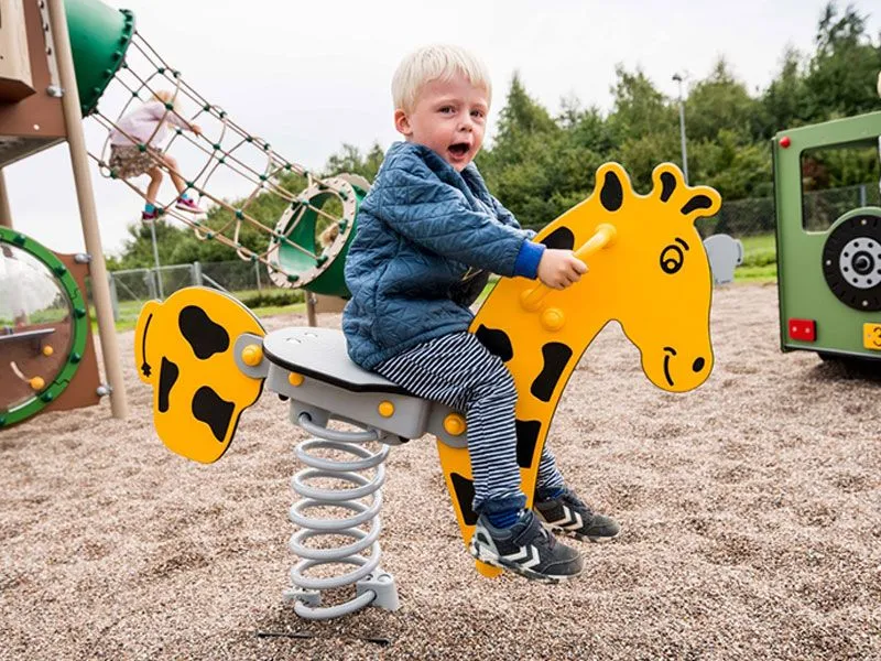 Federwipptier Giraffe mit wippendem Kind Federwipptier Giraffe mit wippendem Kind